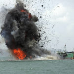 
              FILE - Debris flies into the air as foreign fishing boats are blown up by Indonesian Navy off Batam Island, Indonesia on Monday, Feb. 22, 2016, as authorities sank dozens of fishing boats caught operating illegally in Indonesian waters. Around the world, the ocean has become an expanding front in the armed conflict between nations over illegal fishing and overfishing, practices that deplete a vulnerable food source for billions of people worldwide. (AP Photo/M. Urip, File)
            