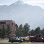 
              Firefighters' vehicles sit as a wildfire burns near the National Center for Atmospheric Research, Sunday, March 27, 2022, in Boulder, Colo. The fire, which started Saturday, is 35 percent contained and most evacuation orders have been lifted for the residents of nearby housing developments in the south end of Boulder. (AP Photo/David Zalubowski)
            