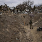 
              A soldier stands inside a crater made by a bomb near Brovary, on the outskirts of Kyiv, Ukraine, Monday, March 28, 2022. (AP Photo/Rodrigo Abd)
            