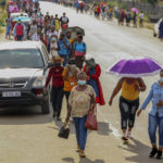 
              Mabuta Irene Kheoane, center, walks along a street in Maseru's garment making district, Lesotho, Friday Feb. 25, 2022. When the coronavirus pandemic hit the world two years ago, the global fashion industry crumpled when faced with collapsing demand, brands canceled orders worth billions of dollars and few felt the effects so harshly as the tens of millions of workers, most of them women, who stitched the world's clothes. (AP Photo/Neo Ntsoma)
            