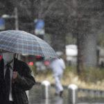 
              A man wearing a protective mask to help curb the spread of the coronavirus walks in a snowy rain Tuesday, March 22, 2022, in Tokyo. Japan’s government on Tuesday issued a rare blackout alert due to power supply shortages stemming from stoppages of several coal-fired power plants that had shut down by last week’s powerful earthquake, calling on households and companies to conserve power. The alert comes as the Tokyo region faces snow, an unusual cold weather for the season, prompting use of heaters while there was no solar power generation. (AP Photo/Eugene Hoshiko)
            