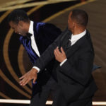 
              Will Smith, right, hits presenter Chris Rock on stage while presenting the award for best documentary feature at the Oscars on Sunday, March 27, 2022, at the Dolby Theatre in Los Angeles. (AP Photo/Chris Pizzello)
            