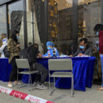 
              Workers wearing protective suits assist people outside a hotel which has requisitioned for emergency use by personnel involved in China Eastern's flight MU5735 incident in Tengxian County in southern China's Guangxi Zhuang Autonomous Region, Tuesday, March 22, 2022. No survivors have been found as rescuers on Tuesday searched the scattered wreckage of a China Eastern plane that crashed a day earlier on a wooded mountainside in China's worst air disaster in more than a decade. (AP Photo/Olivia Zhang)
            