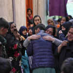 
              Afghan musician Nazir Amir Mohammed is hugged by a relative during an emotional farewell from relatives and neighbors as he prepares to  leave the country for Iran, at Kucha Kharabat street, in Kabul, Afghanistan, Feb. 20, 2022. The songs are silent in the traditional musicians' quarter of Kabul's Old City, ever since the Taliban's takeover of Afghanistan six months ago. (AP Photo/Hussein Malla)
            