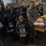 
              Relatives and friends mourn at the funeral of senior police sergeant Roman Rushchyshyn in the village of Soposhyn, outskirts of Lviv, western Ukraine, Thursday, March 10, 2022, in Lviv. Rushchyshyn, a member of the Lviv Special Police Patrol Battalion, was killed in the Luhansk Region. (AP Photo/Bernat Armangue)
            