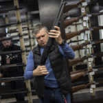 
              A customer checks his rifle in a gun shop in Lviv, western Ukraine, Wednesday, March 23, 2022. The rush for guns and gun training continued in the western city of Lviv. The state of war has streamlined gun purchasing in Ukraine, now simplified. (AP Photo/Bernat Armangue)
            