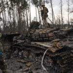 
              A Ukrainian soldier stands one top of a destroyed Russian tank on the outskirts of Kyiv, Ukraine, Thursday, March 31, 2022. (AP Photo/Rodrigo Abd)
            