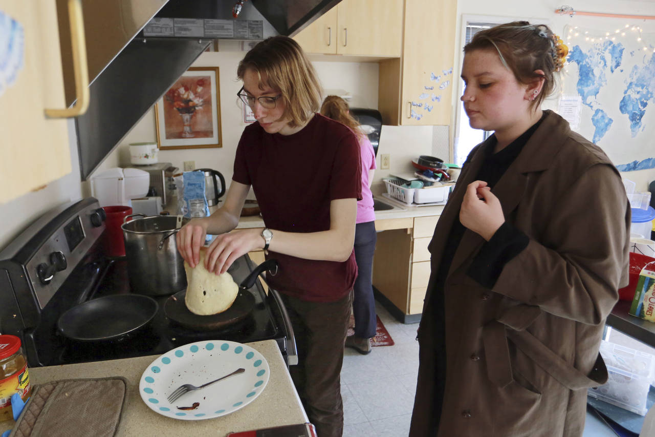 Students Sophia Pavlenko, left, of Russia, and Masha Novikova, of Ukraine, prepare blini, the Easte...