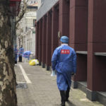 
              A worker in protective gear labelled with "Willing Ox" meaning public service, walks in a locked down community where residents are to take part in the first round of mass COVID testing in the Jingan district of western Shanghai, China, Friday, April 1, 2022. As residents of western Shanghai start a four day lockdown for mass testing, some in eastern Shanghai about to end their lock down are being told they will be confined to their homes for at least 10 more days. It was the latest wrinkle in the lockdown of China's largest city as it struggles to eliminate an omicron-driven coronavirus outbreak under China's zero-COVID policy. (AP Photo/Chen Si)
            