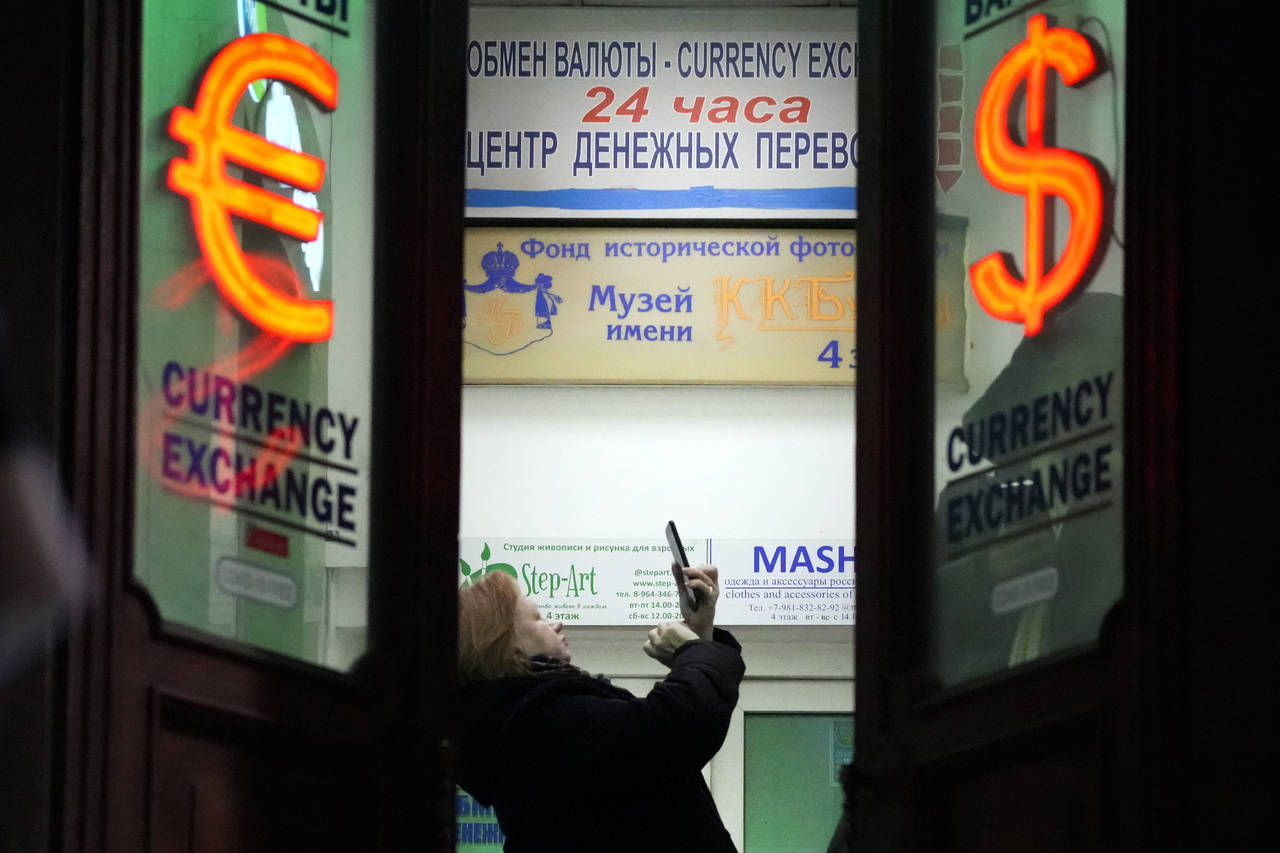 FILE - A woman stands in a currency exchange office in St. Petersburg, Russia, on Feb. 25, 2022. Ru...