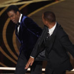 
              Will Smith, right, hits presenter Chris Rock on stage while presenting the award for best documentary feature at the Oscars on Sunday, March 27, 2022, at the Dolby Theatre in Los Angeles. (AP Photo/Chris Pizzello)
            