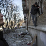 
              Neighbours try to clear the damage from apartments after shelling, in Kyiv, Ukraine,Wednesday, March 23, 2022. (AP Photo/Rodrigo Abd)
            
