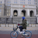 
              A cyclist rides past outside the Beijing No.2 Intermediate People's Court before the trial of Chinese-Australian business reporter Cheng Lei on Thursday, March 31, 2022, in Beijing. Journalist groups have renewed calls for the release of Chinese-Australian business reporter Cheng Lei before her trial in Beijing on espionage charges. (AP Photo/Ng Han Guan)
            