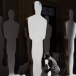 
              A worker prepares Oscar statue cutouts during preparations for Sunday's 94th Academy Awards outside the Dolby Theatre on Friday, March 25, 2022, in Los Angeles. (AP Photo/John Locher)
            