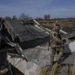 
              A soldier stands on a bridge destroyed by the Ukrainian army to prevent the passage of Russian tanks near Brovary, in the outskirts of Kyiv, Ukraine, Monday, March 28, 2022. (AP Photo/Rodrigo Abd)
            