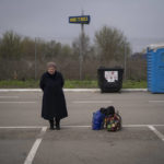 
              Helena stands next to her belongings after arriving from Mariupol at a refugee center in Zaporizhzhia, Ukraine, Thursday, April 21, 2022, after fleeing from the Russian attacks. Mariupol, which is part of the industrial region in eastern Ukraine known as the Donbas, has been a key Russian objective since the Feb. 24 invasion began. (AP Photo/Leo Correa)
            