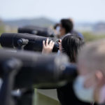 
              Visitors use binoculars to see the North Korean side from the unification observatory in Paju, South Korea, Friday, April 15, 2022. North Korea is marking a key state anniversary Friday with calls for stronger loyalty to leader Kim Jong Un, but there was no word on an expected military parade to display new weapons amid heightened animosities with the United States. (AP Photo/Lee Jin-man)
            