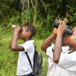 
              In this photo provided by the Dian Fossey Gorilla Fund, students use binoculars for birdwatching in the Nkuba Conservation Area in the Democratic Republic of Congo on May 7, 2021, as part of the Dian Fossey Gorilla Fund’s efforts to educate the next generation of conservationists. On Friday, April 22, 2022, the nonprofit fund announced that more land in eastern Democratic Republic of Congo where Grauer's gorillas live will fall under a community-protection initiative. (Dian Fossey Gorilla Fund via AP)
            