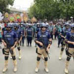 
              Security officers stand in front of a procession being taken out to mark the New Year in Dhaka, Bangladesh, Wednesday, April 14, 2022. After a two-year break, thousands of people in Bangladesh and Nepal on Thursday celebrated their respective new years with colorful processions and musical soirees as the coronavirus pandemic eased and life swung back to normal. (AP Photo/Al Emrun Garjon)
            