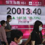 
              People wearing face masks walk past a bank's electronic board showing the Hong Kong share index in Hong Kong, Tuesday, April 26, 2022. Asian shares were mostly higher Tuesday after U.S. stocks stormed back from sharp losses to log strong gains. (AP Photo/Kin Cheung)
            