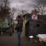 
              A civil defence volunteer stands guard at a checkpoint controlling the traffic near Kyiv, Ukraine on Thursday, April 21, 2022. (AP Photo/Emilio Morenatti)
            