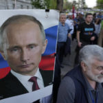 
              A man holds a picture of Russian President Vladimir Putin during a protest against the Serbian authorities for voting to suspend Russia's membership in the UN Human Rights Council in Belgrade, Serbia, Friday, April 15, 2022. Much of the pro-Russia sentiments among Serbs comes from their hatred of NATO; the Western military alliance bombed the country in 1999 to stop a bloody Serb crackdown on ethnic Albanians seeking independence for Kosovo, a Serbian province at the time. (AP Photo/Darko Vojinovic)
            