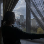 
              Olha Salivonchuk, head of the local association of apartment owners, looks out of the window in her living area, at her apartment, in Lviv, western Ukraine, Sunday, April 3, 2022. Olha has never considered leaving, even when a Russian airstrike in Lviv made their building shake. (AP Photo/Nariman El-Mofty)
            