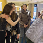 
              Larysa Haivoronska, left, hugs Yevangelina Tkalento as Oleksandra Mudrak, center, looks on at a New York hotel, April 8, 2022, after spending nearly a week together taking part in the National Model United Nations Conference. The Ukrainian college students have been torn about returning to their war-torn homeland. (AP Photo/Bobby Caina Calvan)
            