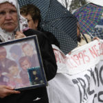 
              FILE - Bosnian Muslim women, and survivors of the Srebrenica massacre carry photos of relatives and display a banner with names of missing relatives, during a peaceful protest walk, in Tuzla, 72 kms north of Bosnian capital of Sarajevo, Sunday, April 12, 2010. Survivors of war crimes committed during Bosnia’s 1992-95 war say the victims of ongoing human rights abuses in Ukraine should learn from their experience of fighting for justice, but that they must first make peace with the fact that reaching it will inevitably be a lengthy and painful process. It took decades to arrest and try the wartime Bosnian Serb leaders, and three decades since the start of that war more than 7,000 people remain unaccounted-for. (AP Photo/Amel Emric, File)
            
