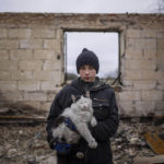 
              Danyk Rak, 12, holds a cat standing on the debris of his house destroyed by Russian forces' shelling in the outskirts of Chernihiv, Ukraine, Wednesday, April 13, 2022. After shelling Danyk's mother Liudmila Koval had to have her leg amputated and was injured in her abdominal cavity. She is still waiting for proper medical treatment. (AP Photo/Evgeniy Maloletka)
            
