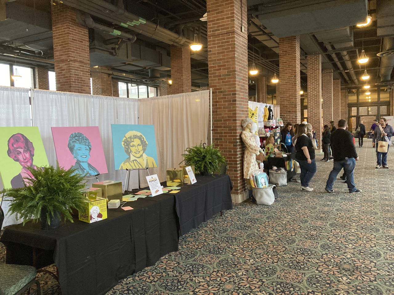 Attendees walk around a vendors' market at the first ever "The Golden Girls" fan convention Friday,...