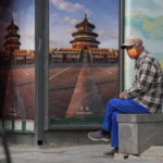 
              A resident wearing a mask rests near a news stand on Sunday, April 10, 2022, in Beijing. (AP Photo/Ng Han Guan)
            