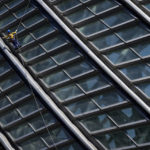 
              A window washer descends on a rope as he cleans the window panels of the Phoenix Center, Sunday, April 3, 2022, in Beijing. (AP Photo/Andy Wong)
            