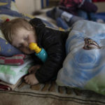 
              3 year-old Carolina Fedorova sleeps inside a school that is being used as a shelter for people who fled the war, in Dnipro city, Ukraine on Tuesday, April 12, 2022. Carolina fled with her parents and four siblings from the city of Bahmud. (AP Photo/Petros Giannakouris)
            