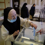 
              A nun of the Baumgarten abbey casts her vote in the first round of the French presidential election, in Bernardville, eastern France Sunday, April 10, 2022. The polls opened at 8am in France for the first round of its presidential election where up to 48 million eligible French voters will be choosing between 12 candidates. (AP Photo/Jean-Francois Badias)
            