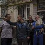 
              Residents talk outside a burning apartment building following a Russian bombardment in Kharkiv, Ukraine, Monday, April 25, 2022. (AP Photo/Felipe Dana)
            