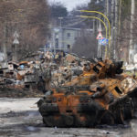 
              Ukrainian soldiers examine destroyed Russian military vehicles following a battle in Bucha, close to Kyiv, Ukraine, Monday, April 4, 2022. Russia is facing a fresh wave of condemnation after evidence emerged of what appeared to be deliberate killings of dozens if not hundreds of civilians in Ukraine. (AP Photo/Efrem Lukatsky)
            