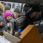 
              Local residents get volunteers' humanitarian aid in Bucha close to Kyiv, Ukraine, Tuesday, Apr. 5, 2022. Ukraine’s president told the U.N. Security Council on Tuesday that the Russian military must be brought to justice immediately for war crimes, accusing invading troops of the worst atrocities since World War II. He stressed that Bucha was only one place and there are more with similar horrors. (AP Photo/Efrem Lukatsky)
            