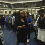 
              Rep. Dotie Joseph, D-North Miami leads fellow Democrat protesters in prayer as debate stops on Senate Bill 2-C: Establishing the Congressional Districts of the State in the House of Representatives Thursday, April 21, 2022 at the Capitol in Tallahassee, Fla. The session was halted on the protest, but resumed after a brief recess. (AP Photo/Phil Sears)
            