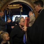 
              A little girl watches as her mother kisses the Gospel book as she enters the church, Friday, April 22, 2022, during a Good Friday service at St. Mary's Ukrainian Orthodox Cathedral in Allentown, Pa.. While Easter is the most joyous of holy days on the church calendar, marking the day Christians believe Jesus triumphed over death, many members of Ukrainian Orthodox churches across the United States are finding it difficult to summon joy at a time of war. (AP Photo/Wong Maye-E)
            