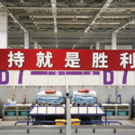 
              In this photo released by Xinhua News Agency, a worker in protective clothing walks past a banner reading "Persistence is victory!" at a makeshift hospital and quarantine facility at the National Exhibition and Convention Center in Shanghai, Monday, April 11, 2022. The U.S. has ordered all non-emergency consular staff to leave Shanghai, which is under a tight lockdown to contain a COVID-19 surge. (Ding Ting/Xinhua via AP)
            