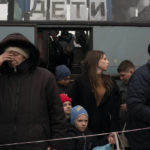 
              People from Mariupol and nearby towns step out a bus, with a sign on the window that reads in Russian: "Children", and arrive at a refugee center fleeing from the war, in Zaporizhzhia, Ukraine, Thursday, April 21, 2022. Mariupol, which is part of the industrial region in eastern Ukraine known as the Donbas, has been a key Russian objective since the Feb. 24 invasion began. (AP Photo/Leo Correa)
            