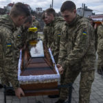 
              Soldiers prepare to place the Ukrainian flag on the coffin of 41-year-old soldier Simakov Oleksandr, during his funeral ceremony, after he was killed in action, at the Lychakiv cemetery, in Lviv, western Ukraine, Monday, April 4, 2022. (AP Photo/Nariman El-Mofty)
            