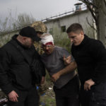 
              Member of security forces help an injured man following a Russian bombing of a factory in Kramatorsk, eastern Ukraine, Tuesday, April 19, 2022, killing at least one person and injuring three others. Russian forces attacked along a broad front in eastern Ukraine on Tuesday as part of a full-scale ground offensive to take control of the country's eastern industrial heartland in what Ukrainian officials called a "new phase of the war." (AP Photo/Petros Giannakouris)
            