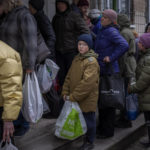 
              Sergei, 11, waits his turn to receive donated food during an aid humanitarian distribution in Bucha, in the outskirts of Kyiv, on Tuesday, April 19, 2022. Citizens of Bucha are still without electricity, water and gas after more than 44 days since the Russian invasion began. (AP Photo/Emilio Morenatti)
            