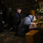 
              Worshippers kiss what represent the coffin of Jesus Christ during Easter Orthodox Christian celebrations at the Saints Peter and Garrison church in Lviv, western Ukraine, Friday, April 22, 2022. New satellite images show apparent mass graves near Mariupol, where local officials accused Russia of burying up to 9,000 Ukrainian civilians to conceal the slaughter taking place in the ruined port city that's almost entirely under Russian control. (AP Photo/Francisco Seco)
            