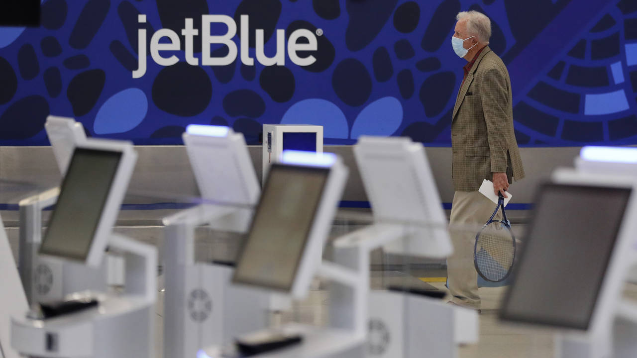 A traveler wearing a protective mask, due to the coronavirus outbreak, walks through the nearly emp...