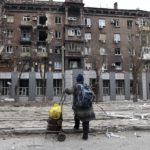 
              A local resident looks at a damaged during a heavy fighting apartment building near the Illich Iron & Steel Works Metallurgical Plant, the second largest metallurgical enterprise in Ukraine, in an area controlled by Russian-backed separatist forces in Mariupol, Ukraine, Saturday, April 16, 2022. Mariupol, a strategic port on the Sea of Azov, has been besieged by Russian troops and forces from self-proclaimed separatist areas in eastern Ukraine for more than six weeks. (AP Photo/Alexei Alexandrov)
            