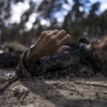 
              The charred body of a man along with five other people, lie on the ground in Bucha, on the outskirts of Kyiv, Ukraine, Monday, April 4, 2022. Russia is facing a fresh wave of condemnation after evidence emerged of what appeared to be deliberate killings of civilians in Ukraine. (AP Photo/Rodrigo Abd)
            