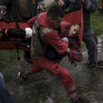 
              An emergency worker is helped by locals to carry a man to an ambulance following a Russian bombardment in Kharkiv, Ukraine, Wednesday, April 27, 2022. (AP Photo/Felipe Dana)
            